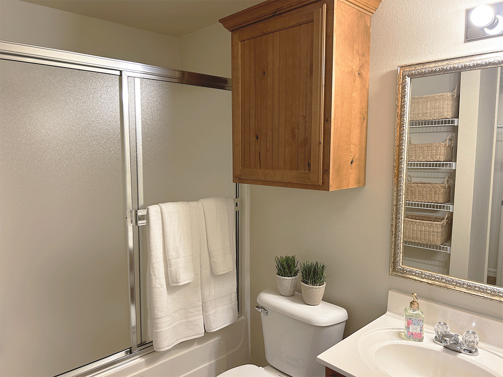 the bathroom has a shower and a toilet and a sink