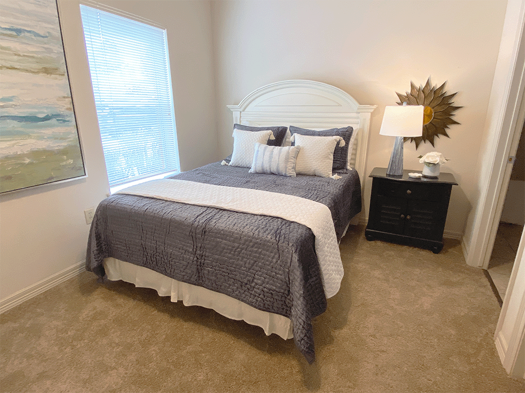 a bedroom with a bed and a dresser and a window