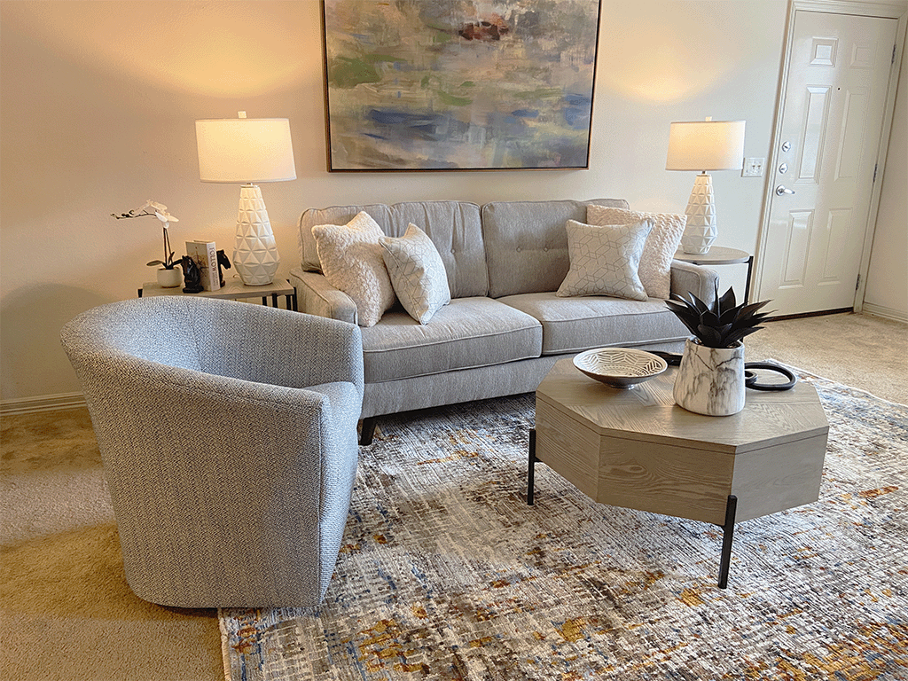 a living room with a couch and chairs and a rug