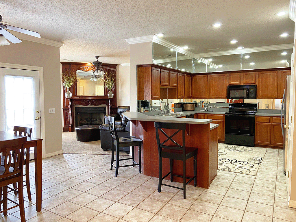 a large kitchen with a center island and a living room