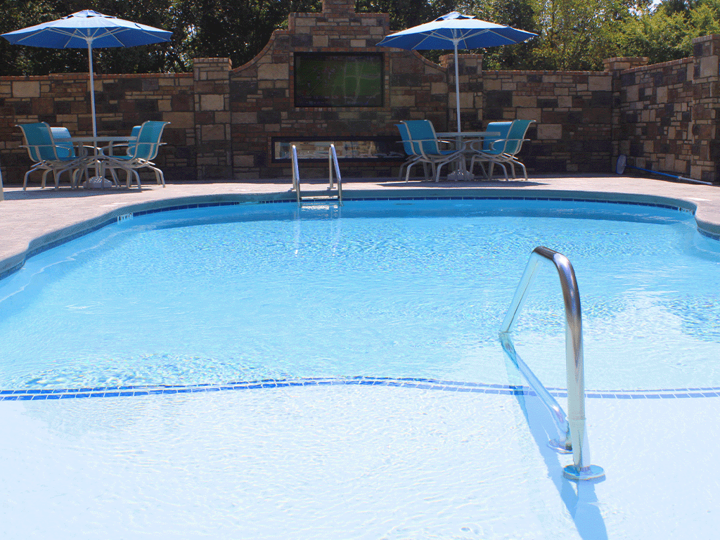 a large swimming pool with chairs and umbrellas
