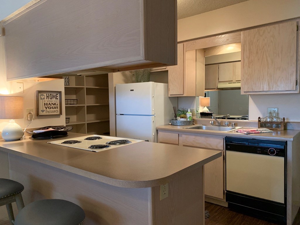 A kitchen with a white refrigerator and a washing machine.