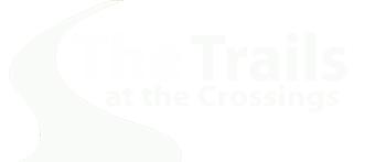 A logo with the text "The Trails at the Crossings" in white on a green background.