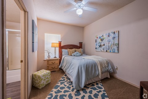 a bedroom with a bed and a ceiling fan