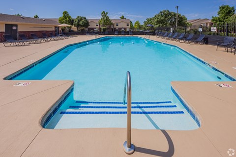 a large swimming pool with chairs around it