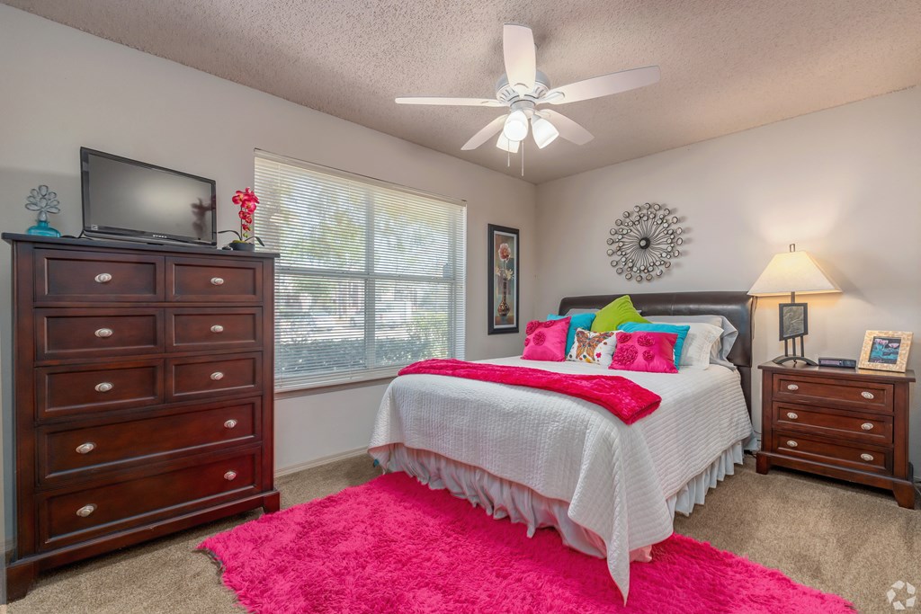 a bedroom with a bed and a ceiling fan