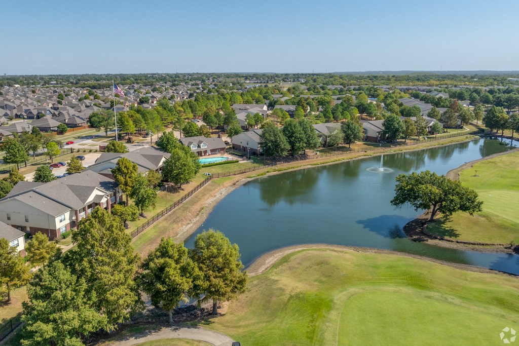an aerial view of a neighborhood with a body of water