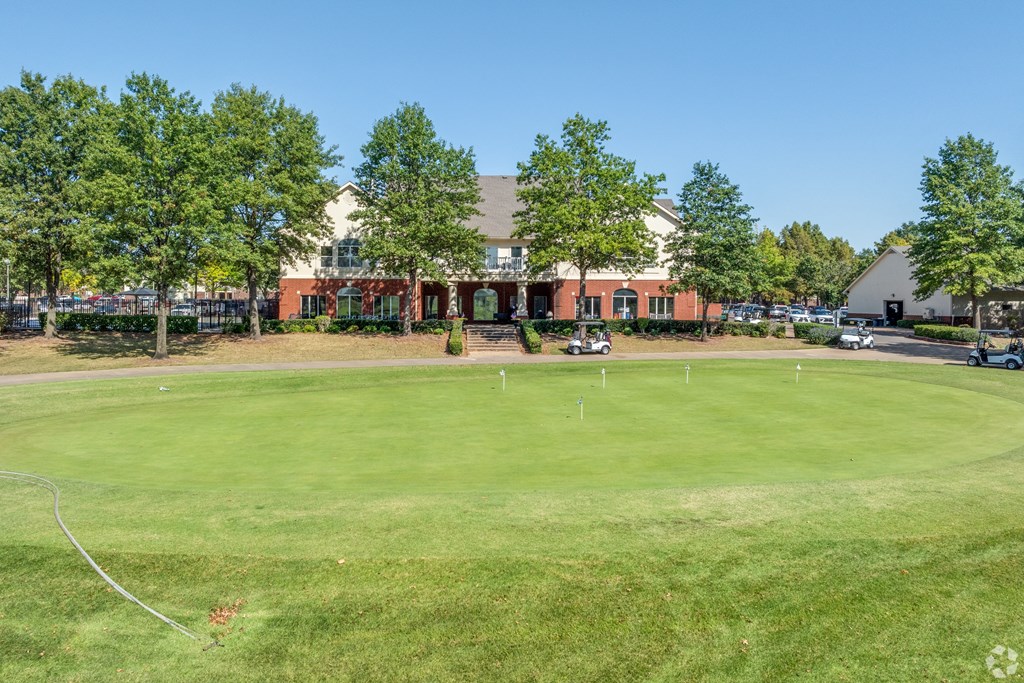 a golf course with a building in the background