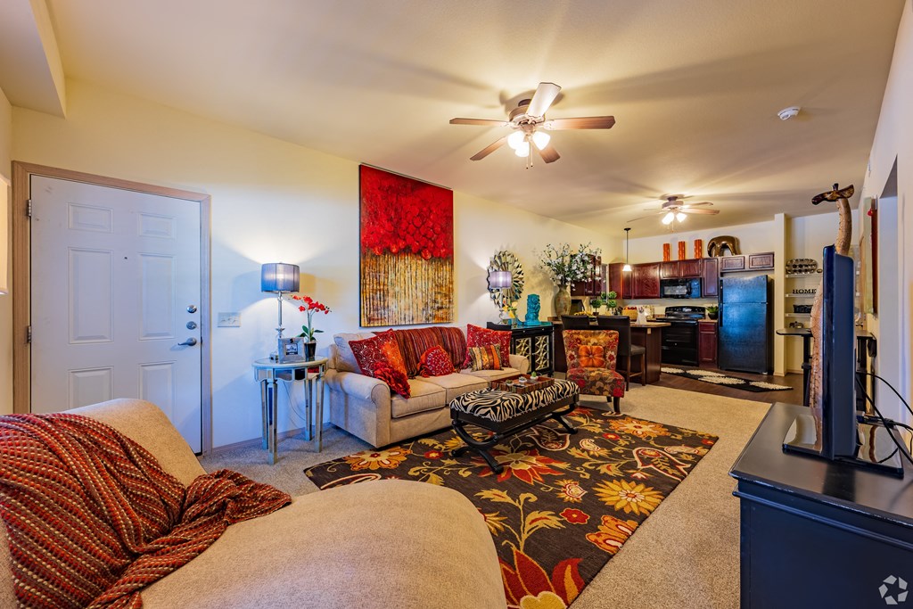 a living room with a couch and a chair and a kitchen