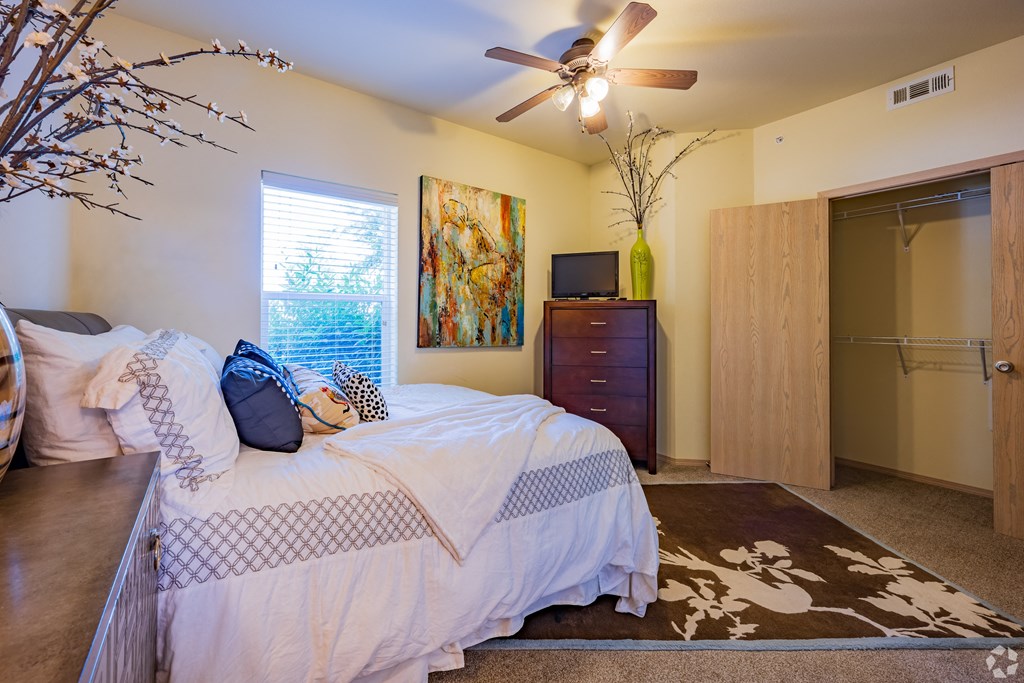 the master bedroom has a large bed and a ceiling fan