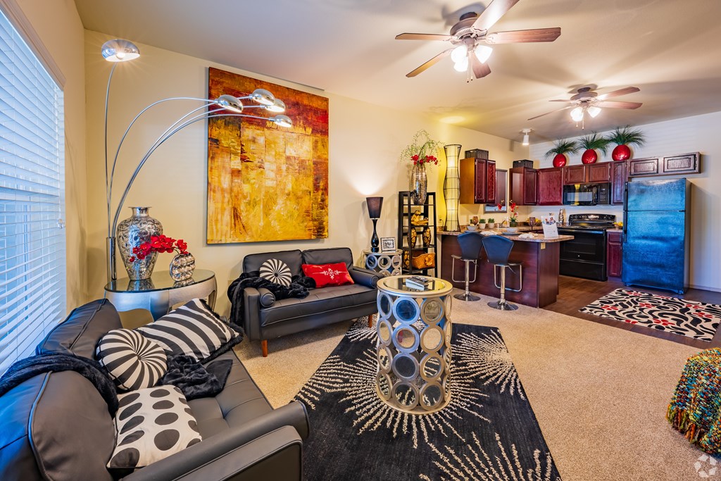 a living room and kitchen with furniture and a ceiling fan