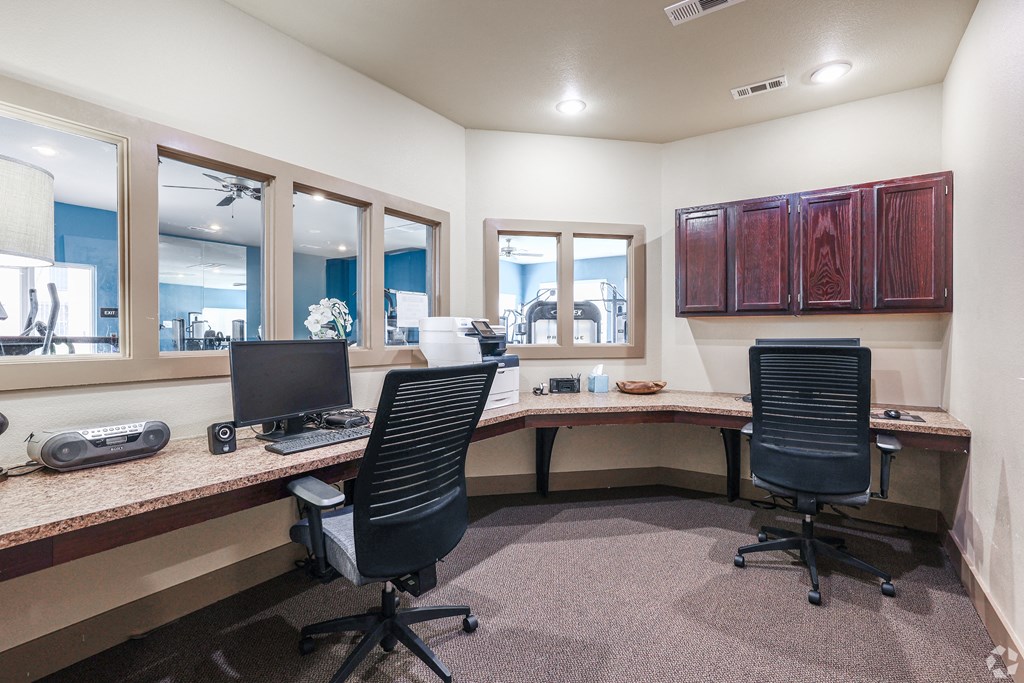 two desks and two chairs in a room with a computer