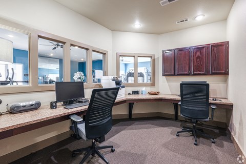two desks and two chairs in a room with a computer