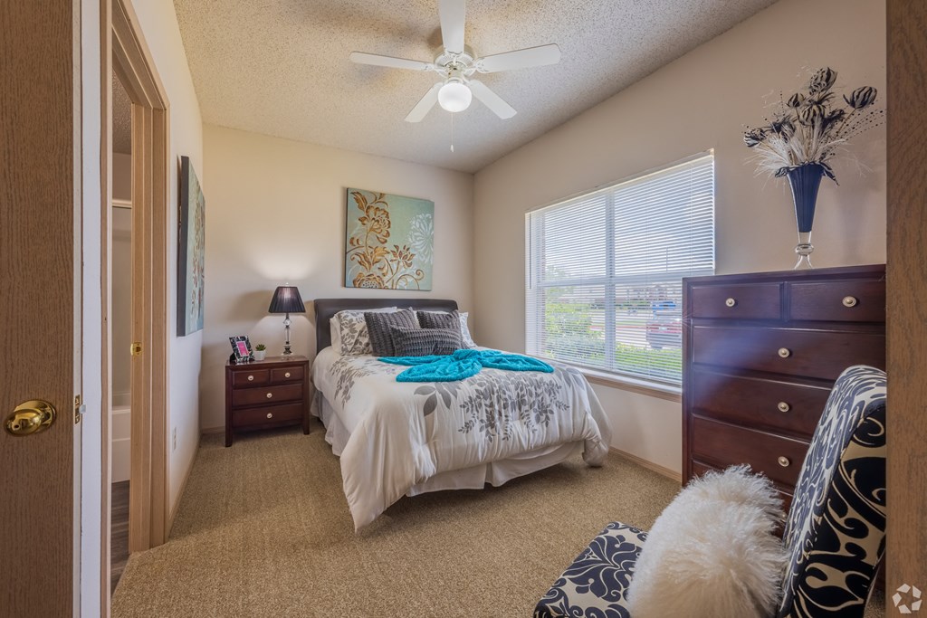a bedroom with a bed and a ceiling fan