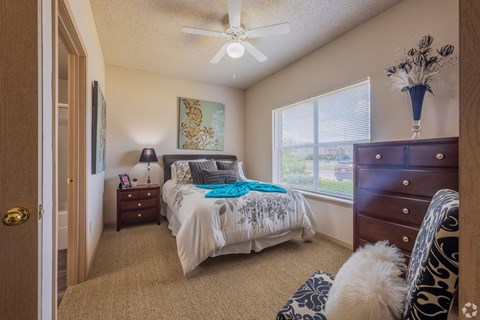 a bedroom with a bed and a ceiling fan