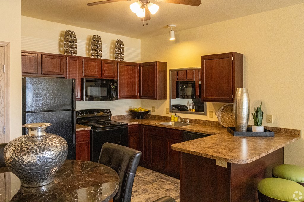 a kitchen with black appliances and a granite counter top