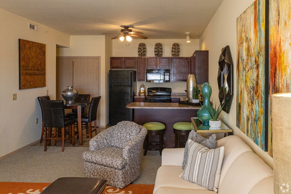 A living room with a couch, chair, and a painting on the wall.