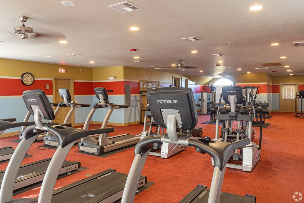 a gym with a lot of treadmills and other exercise equipment
