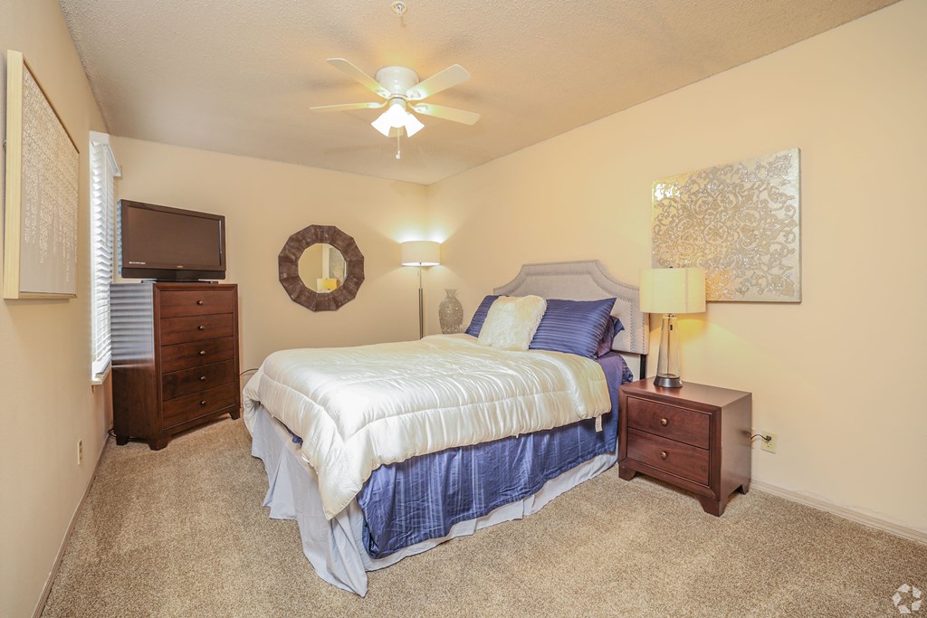 a bedroom with a bed and a ceiling fan