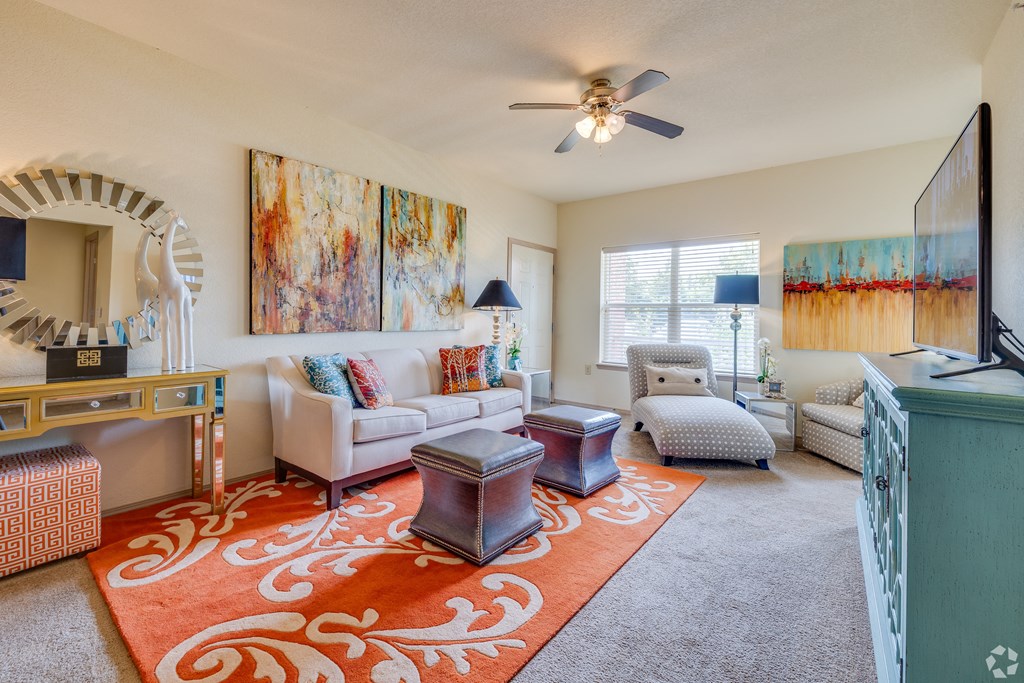 a living room with furniture and a ceiling fan