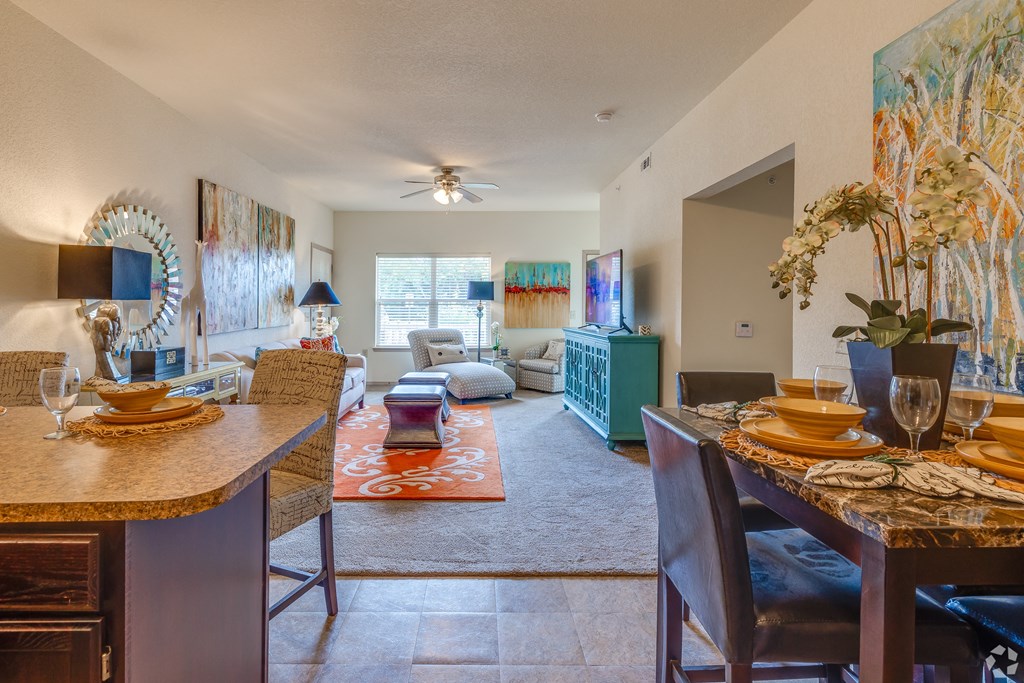 a living room and dining room with a table and chairs