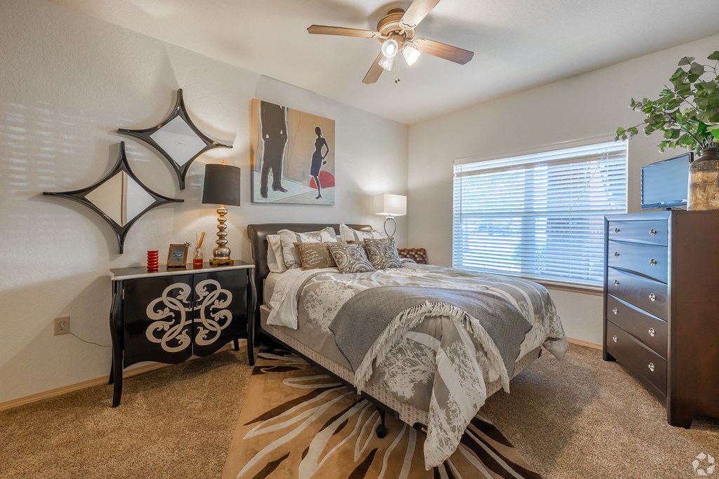 the commons at cortland bedroom with ceiling fan and dresser
