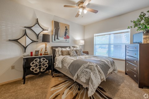 the commons at cortland bedroom with ceiling fan and dresser