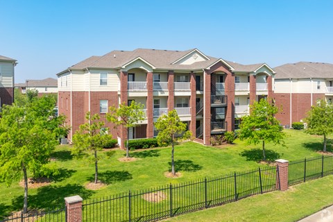 an apartment building with green grass and trees