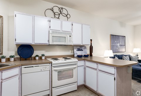 a kitchen with white appliances and white cabinets and a counter top