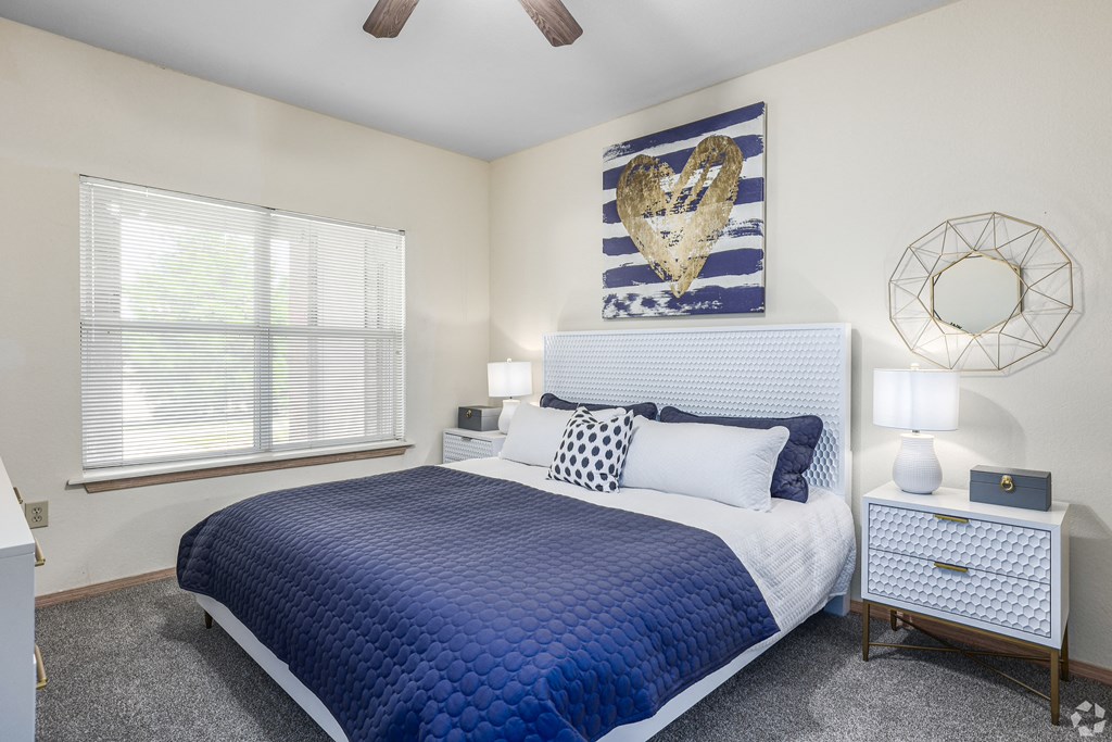 a blue and white bedroom with a bed and a window