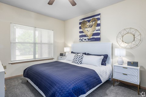 a blue and white bedroom with a bed and a window