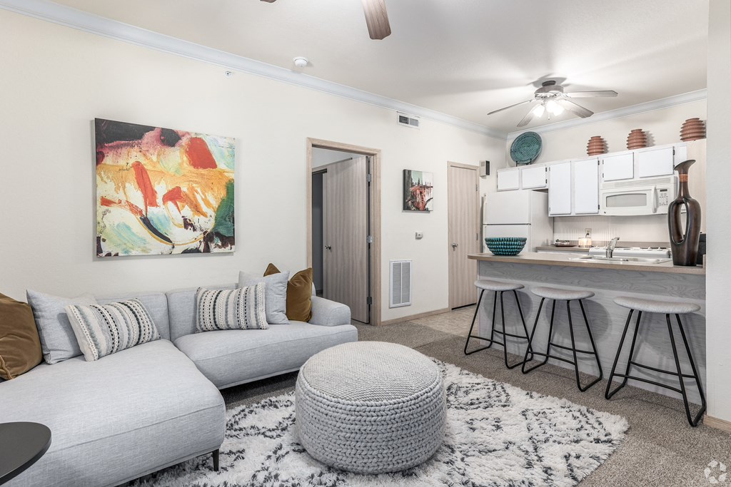 a living room with a couch and a kitchen with a bar
