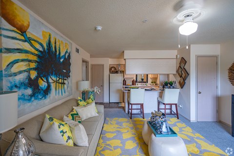 a living room with a couch and a kitchen in the background