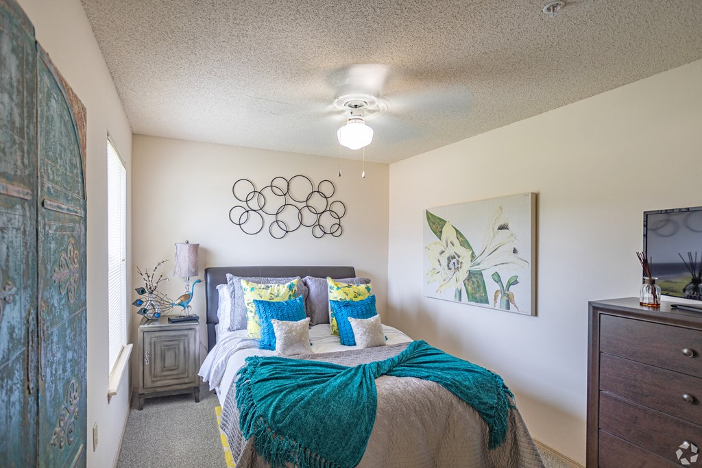 a bedroom with a bed and a ceiling fan