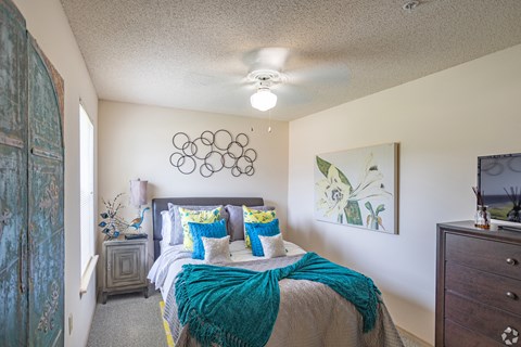 a bedroom with a bed and a ceiling fan