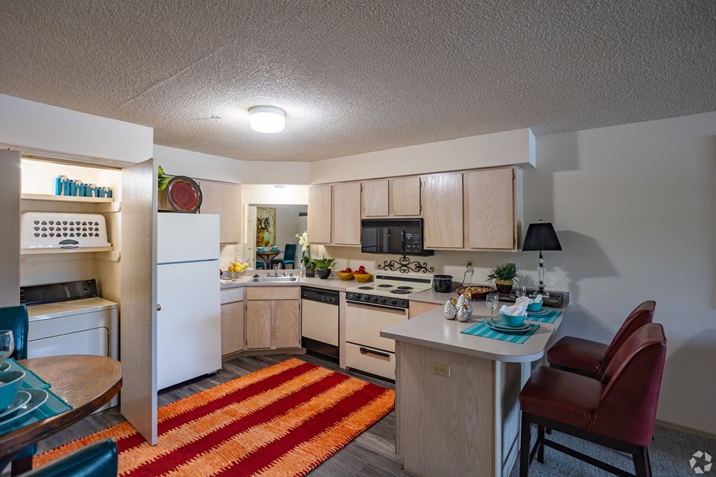 an open kitchen and dining room with a white refrigerator and stove