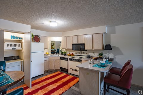 an open kitchen and dining room with a white refrigerator and stove