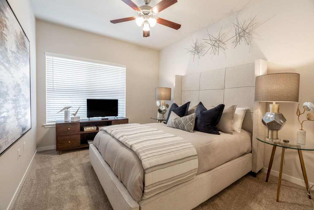 a bedroom with a large bed and a ceiling fan
