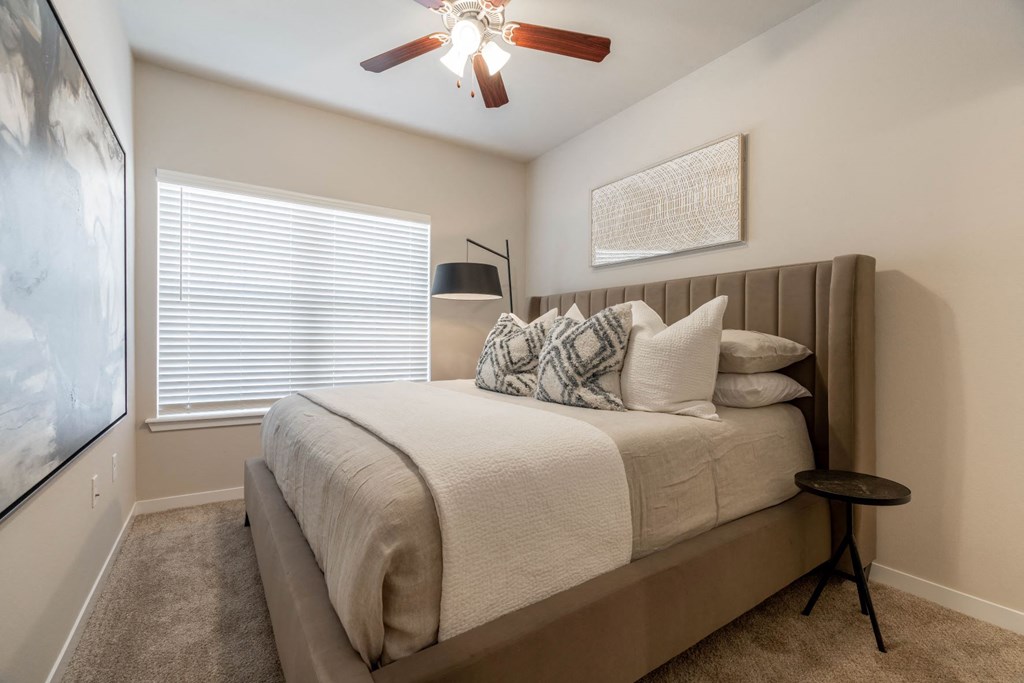 a bedroom with a bed and a ceiling fan