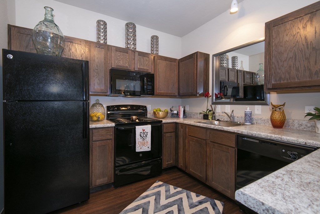 a kitchen with black appliances and wooden cabinets