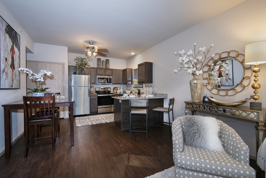 A well-lit kitchen with a dining table and chairs.