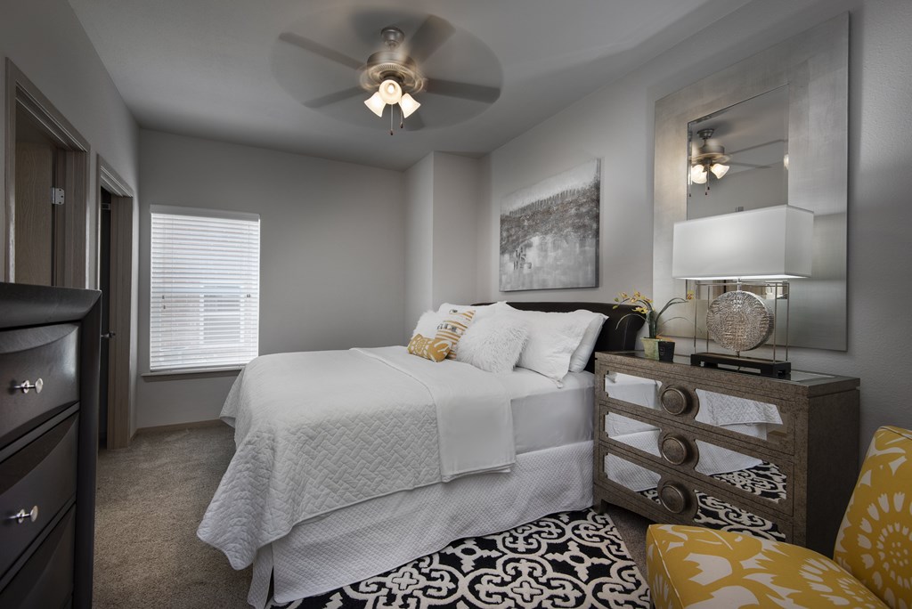 A bedroom with a bed, dresser, and mirror.