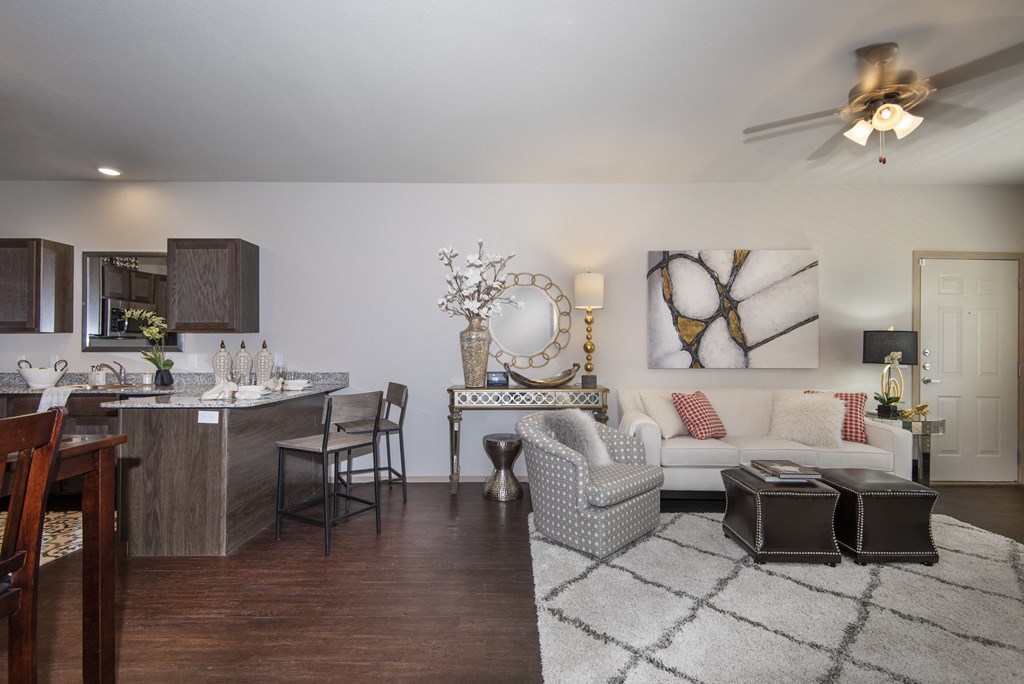 A modern living room with a kitchen area in the background.