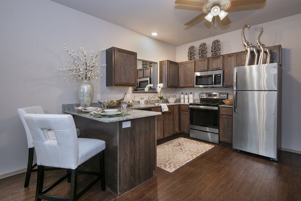 A modern kitchen with a white chair and wooden cabinets.