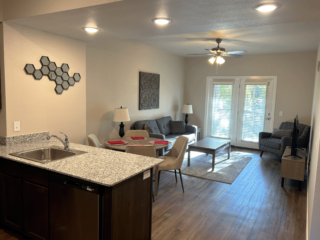 an open kitchen and living room with a couch and a table