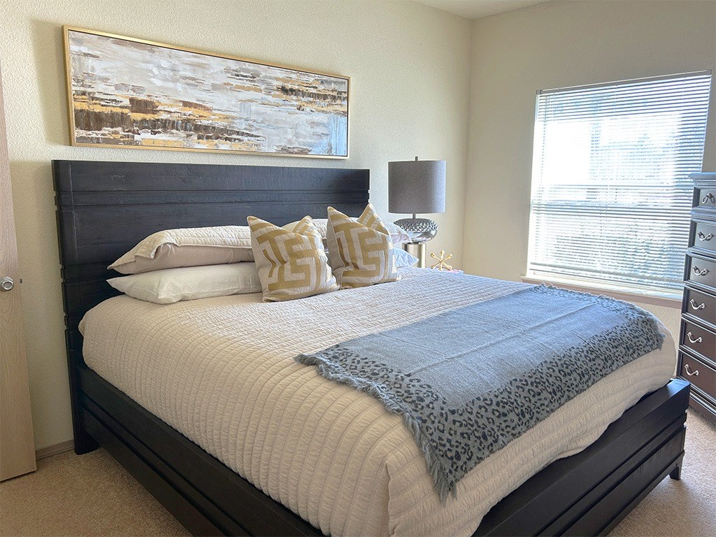 a bedroom with a bed and a painting on the wall