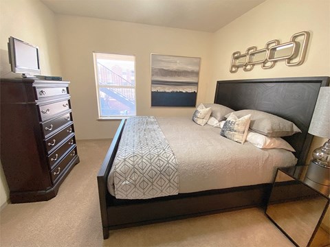 a bedroom with a bed and a dresser and a window