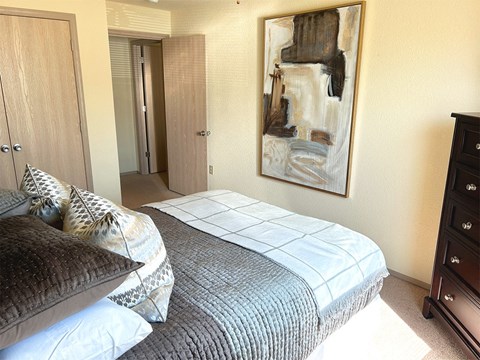 a bedroom with a bed and a painting on the wall