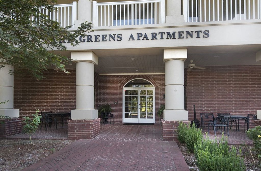 the front of the greens apartments building with a door