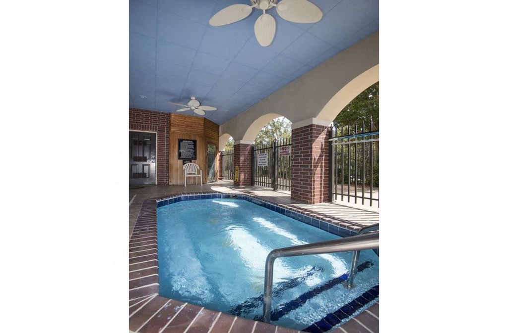 a swimming pool in a house with a ceiling fan